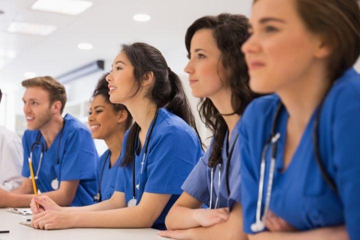 A group of medical students sitting in a classroom smiling