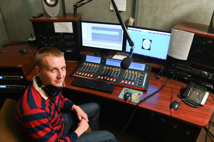 Student sits in front of Perch radio equipment 