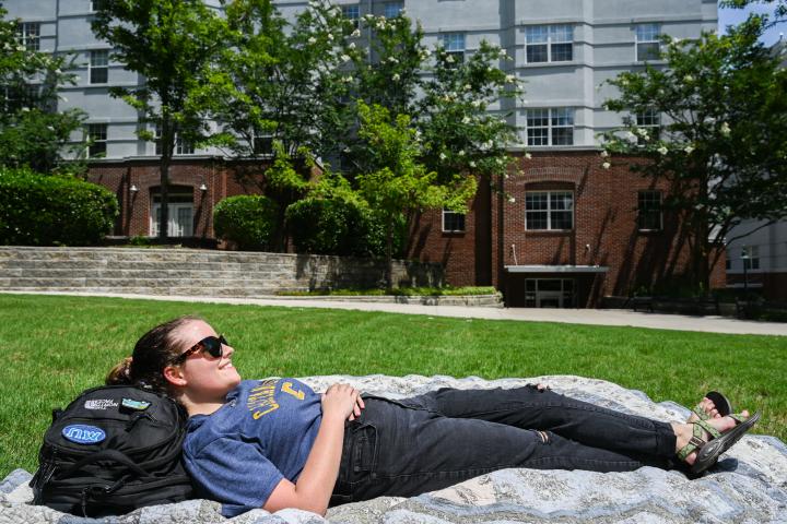 student lying on blanket in Walker/UCF courtyard