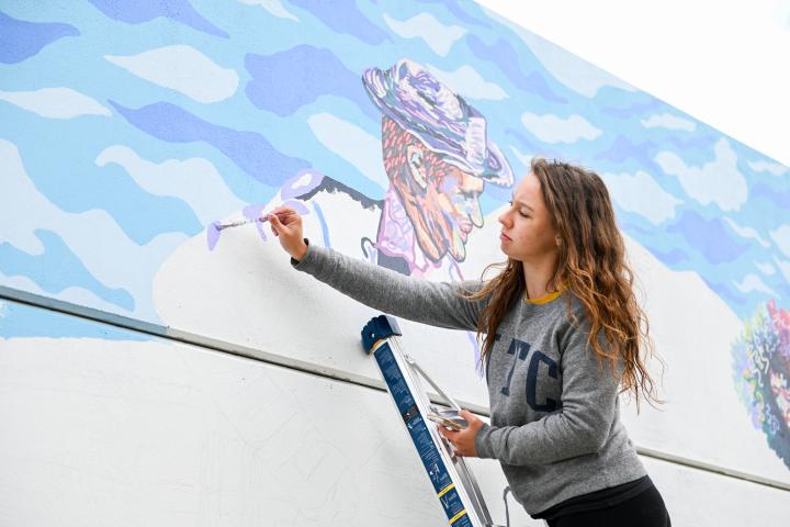 Woman painting a mural 