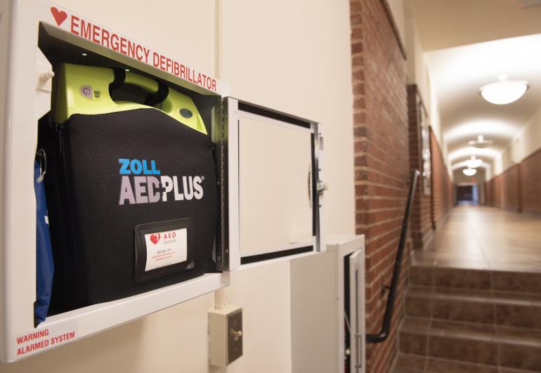 AED emergency defibrillator mounted to a wall in a hallway