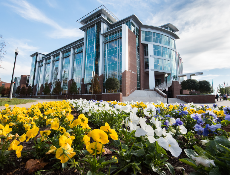 Photograph of the new UTC Library Building with a bed of brightly colored flower in the foreground.