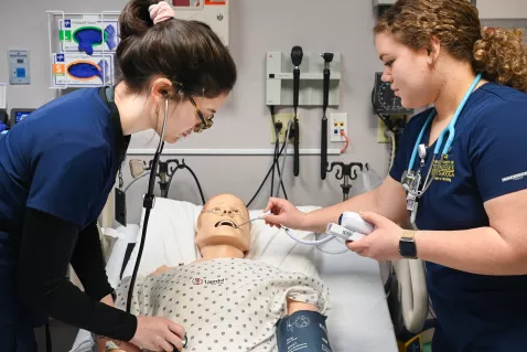 UTC Nursing students practicing on a medical dummy